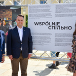 Zastępca prezydenta Miasta, Dyrektorka Centrum Aktywności Społecznej i jej zastępczyni pozują do zdjęcia na tle wystawy. 