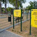 3 żółte tablice informujące o 3 projektach zrealizowanych przy ulicy Szkolnej w ramach Budżetu Obywatelskiego.