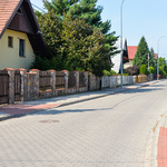 Ulica osiedlowa i obustronne chodniki z kostki brukowej.
