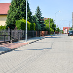 Ulica osiedlowa i obustronne chodniki z kostki brukowej.