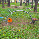 Urządzenie siłowni dla dzieci zamontowane pod drzewami