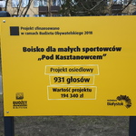 Żółta tabliczka informująca o realizacji projektu ze środków budżetu obywatelskiego