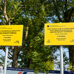 2 żółte tabliczki informujące o budowie drogi ze środków budżetu obywatelskiego.