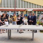 Teren otwarty przed szkołą. Na pierwszym planie stół do pingponga, za nim prezydent Białegostoku oraz uczniowie i nauczyciele. W tle budynek szkoły.