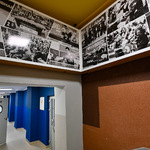 Na górze widok na ścianę udekorowaną zdjęciami sportowców. Poniżej drzwi prowadzące na korytarz.