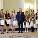 Wnętrze auli. Prezydent Białegostoku pozuje do zdjęcia z nagrodzonymi wolontariuszami 