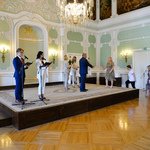 Wnętrze auli. Prezydent Białegostoku wręcza na scenie upominki wolontariuszom.
