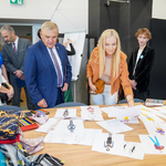 Nauczycielka prezentuje Prezydentowi Białegostoku projekty odzieży przygotowane przez młodzież