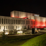 Bryła Muzeum Pamięci Sybiru nocą. Na Elewacji wyświetlone biało czerwone barwy.