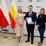 Zastępca prezydenta Miasta pozuje do zdjęcia z dwoma kobietami przybyłymi z Ukrainy. 
