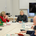 Wiceprzewodnicząca Rady Miasta Białystok siedzi przy dużym stole wśród uczestników posiedzenia.