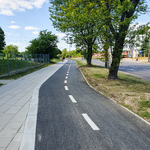 Chodnik dla pieszych z lewej strony wykonany z kwadratowych płyt, po prawej stronie ścieżka rowerowa.