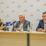 Uczestnicy konferencji siedzący za stołem. 