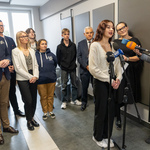 Konferencja prasowa w szkolnej strefie relaksu. Jedna z uczennic szkoły mówi do mikrofonu.