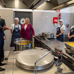Prezydent Tadeusz Truskolaski odwiedza kuchnię w ZST. Przy sprzętach kuchennych stoją pracownice kuchni.