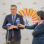 Zastępca prezydenta mówi do mikrofonów, obok niego stoi dziennikarka. 
