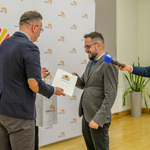 Zastępca prezydenta wręcza podziękowania członkowi ustępującej Rady.