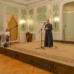 Katolicki Arcybiskup mówi przez mikrofon do osób uczestniczących w gali.