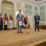 Jakub Klimiuk stoi na środku sceny podczas odbierania wyróżnienia.