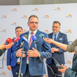 Konferencja prasowa. Przedstawiciel Polskiego Radia Białystok odpowiada na pytania stojących obok dziennikarzy.