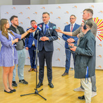 Konferencja prasowa. Zastępca prezydenta Białegostoku odpowiada na pytania stojących obok dziennikarzy.
