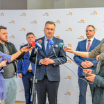 Konferencja prasowa. Zastępca prezydenta Białegostoku odpowiada na pytania stojących obok dziennikarzy.